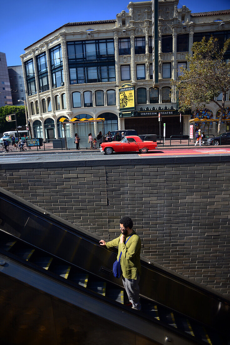 Young man in electric stairs at Market Street, San Francisco.