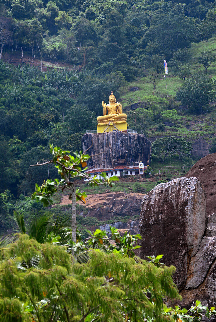 Sitzender goldener Buddha im Aluvihare Rock Temple, Matale, Sri Lanka