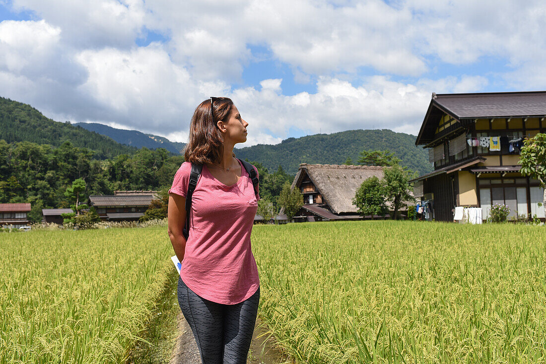 Portrait of a young caucasian woman outdoors in Shirakawa-go, traditional village showcasing a building style known as gassho-zukuri, Gifu Prefecture, Japan