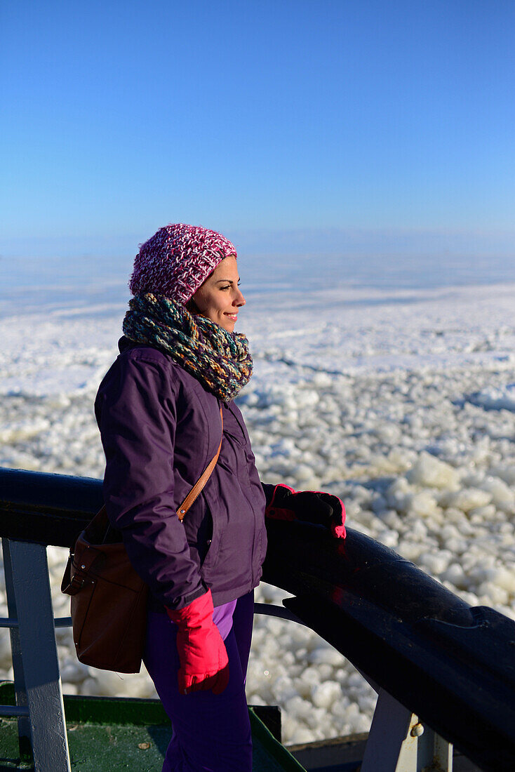 Junge Frau genießt die Fahrt mit dem Sampo Icebreaker, einem authentischen finnischen Eisbrecher, der zu einer Touristenattraktion in Kemi, Lappland, umgebaut wurde