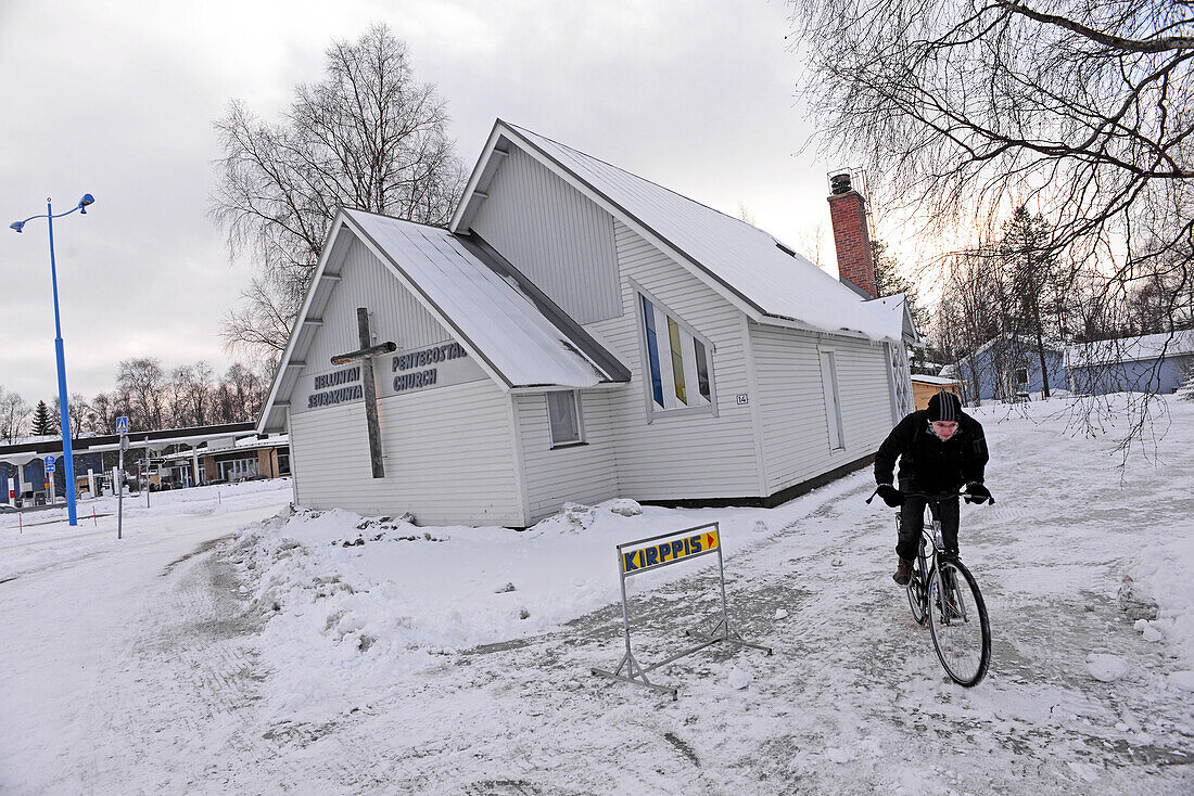 Young man rides bicycle in Ivalo