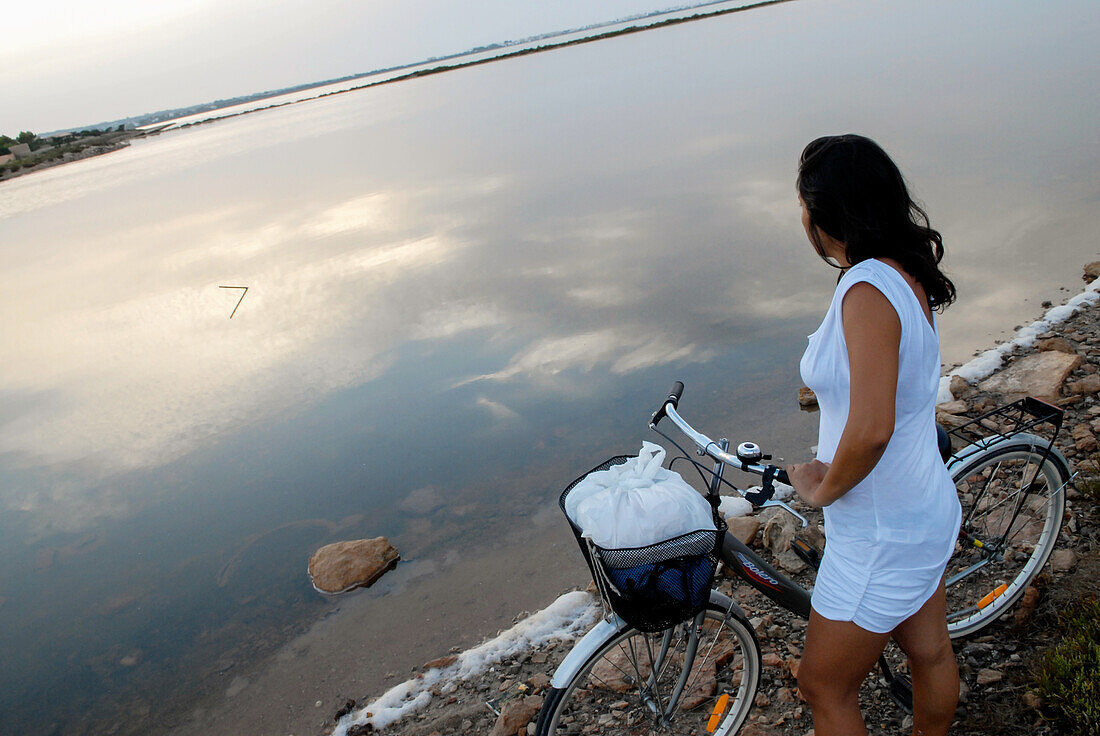 Young attractive brunette woman with her bicycle on the island of Formentera, Balearic Islands, Spain