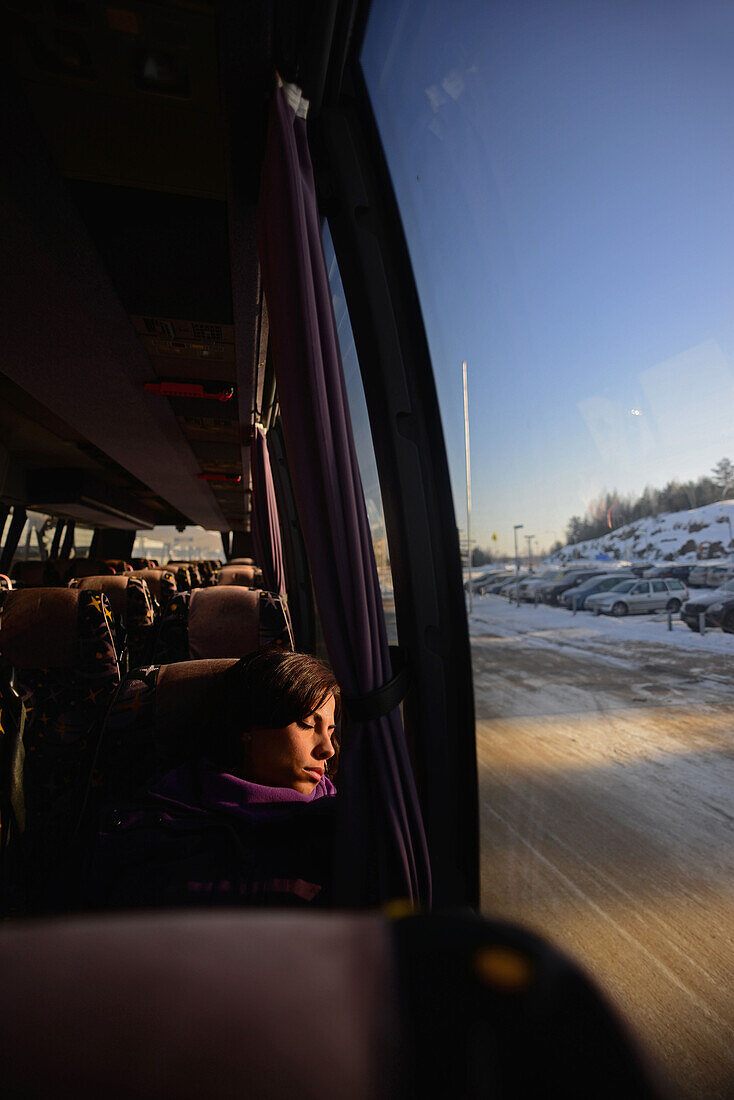 Junge Frau, die mit dem Bus zum Skigebiet Pyh? fährt, Lappland, Finnland