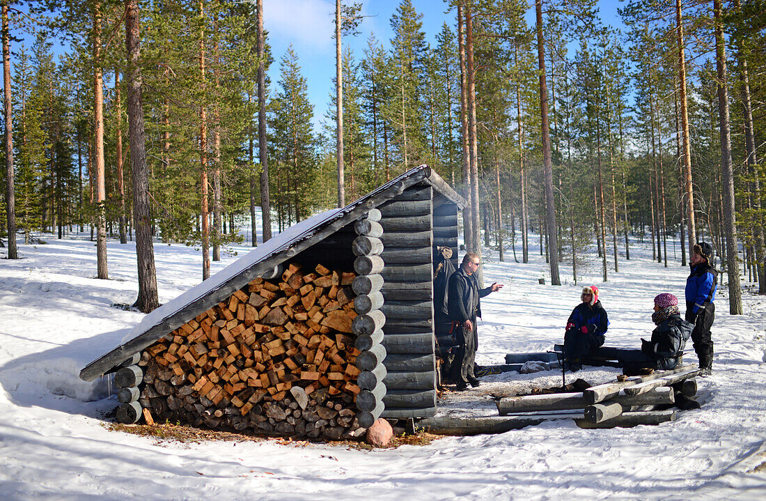 Rast und Feuer in einer Holzhütte. Wildnis-Husky-Schlittentour in der Taiga mit Bearhillhusky in Rovaniemi, Lappland, Finnland