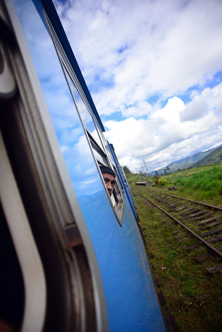 Junger Junge schaut aus dem Fenster. Zugfahrt von Kandy nach Nuwara Eliya, Sri Lanka