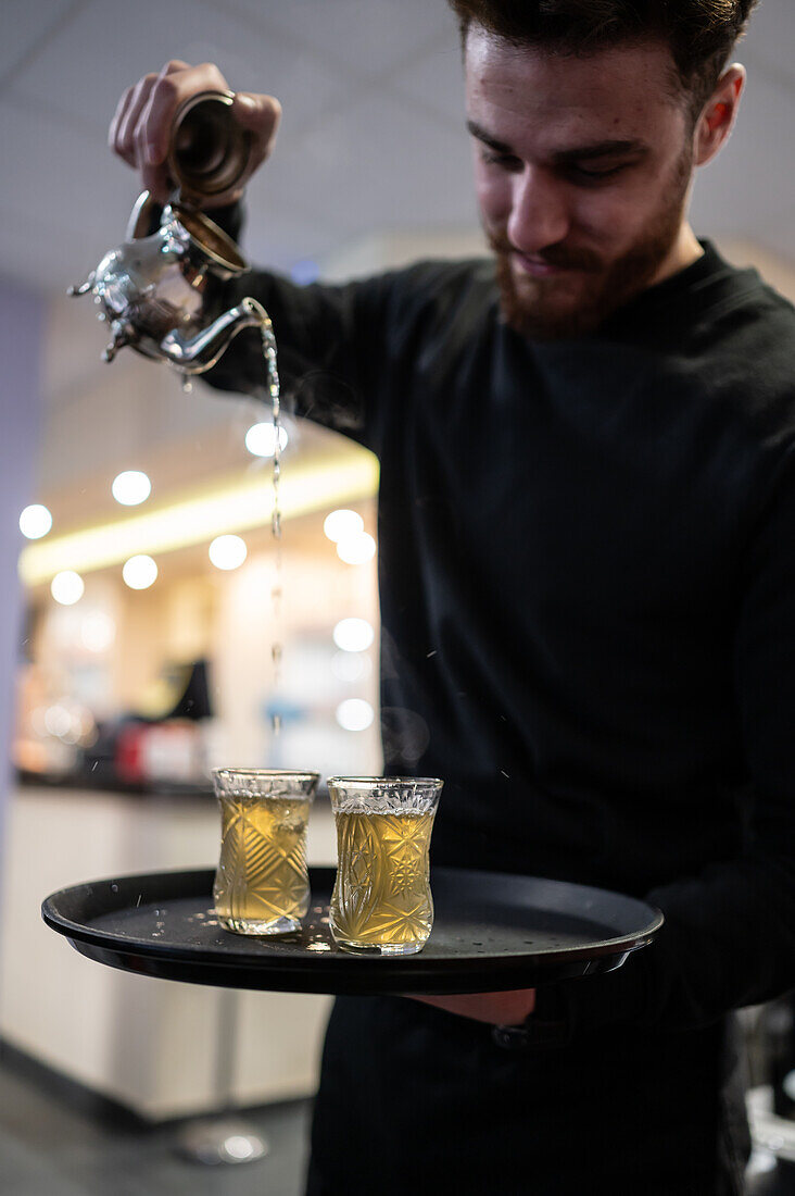 Waiter serving tea in Mosaico restaurant, Zaragoza, Spain