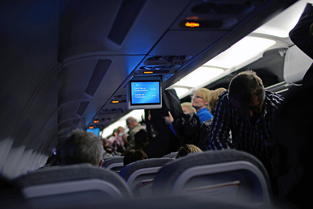 Passengers pick up their luggage at the end of flight