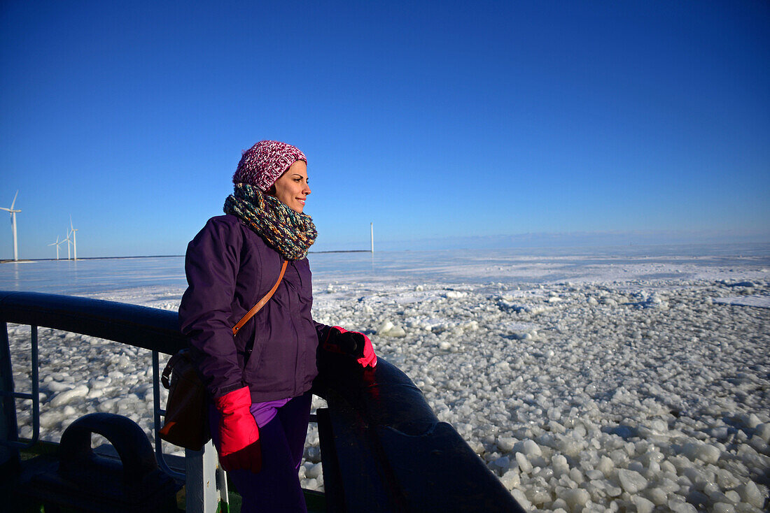 Junge Frau genießt die Fahrt mit dem Sampo Icebreaker, einem authentischen finnischen Eisbrecher, der zu einer Touristenattraktion in Kemi, Lappland, umgebaut wurde