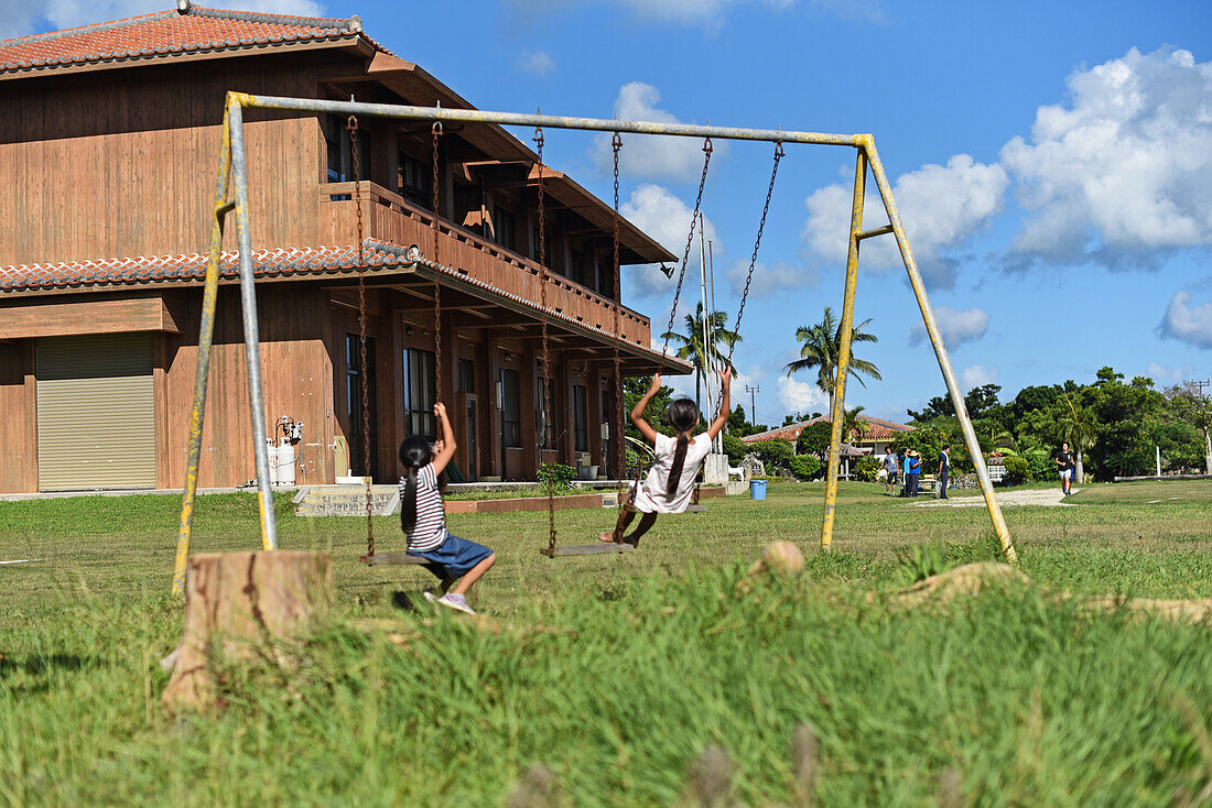 Kinder spielen in einer Schaukel auf der Insel Taketomi, Präfektur Okinawa, Japan