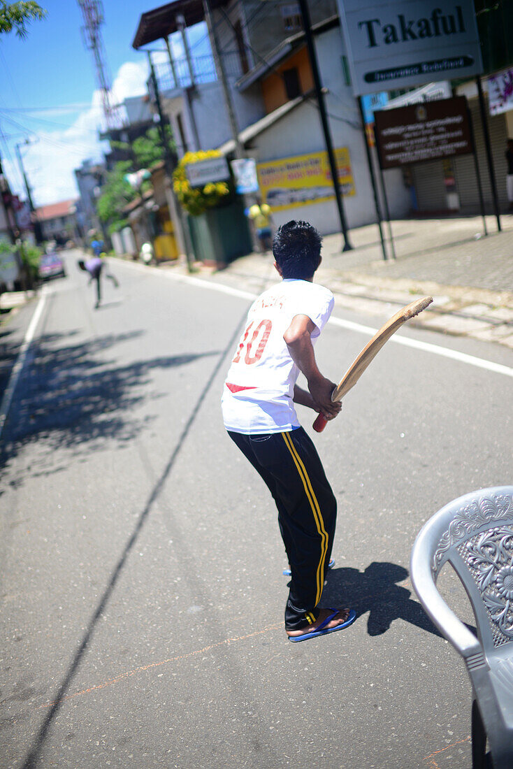 Young boys playing cricket in the street, Galle, Sri Lanka