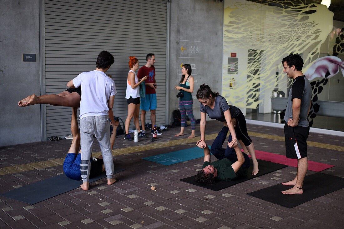 Eine Gruppe von Menschen praktiziert Acroyoga vor dem Museum für moderne Kunst in Medellin (MAMM), Kolumbien