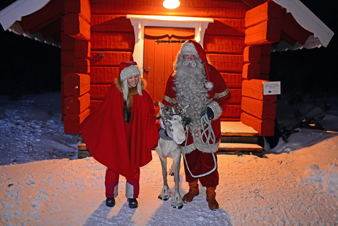 Santa Claus poses with Elf and Reindeer. Santa?s Home in Kakslauttanen Arctic Resort. Lapland, Finland
