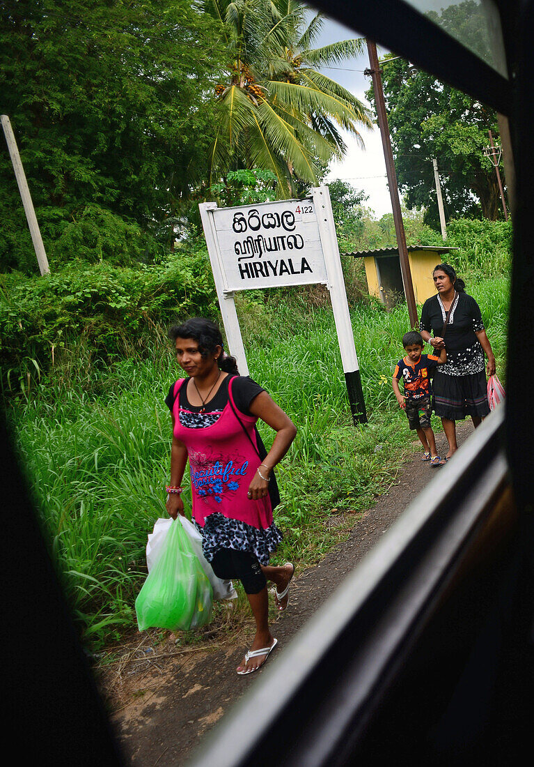 Frau und Mädchen im Bahnhof Hiriyala, Blick aus dem Zugfenster, Sri Lanka