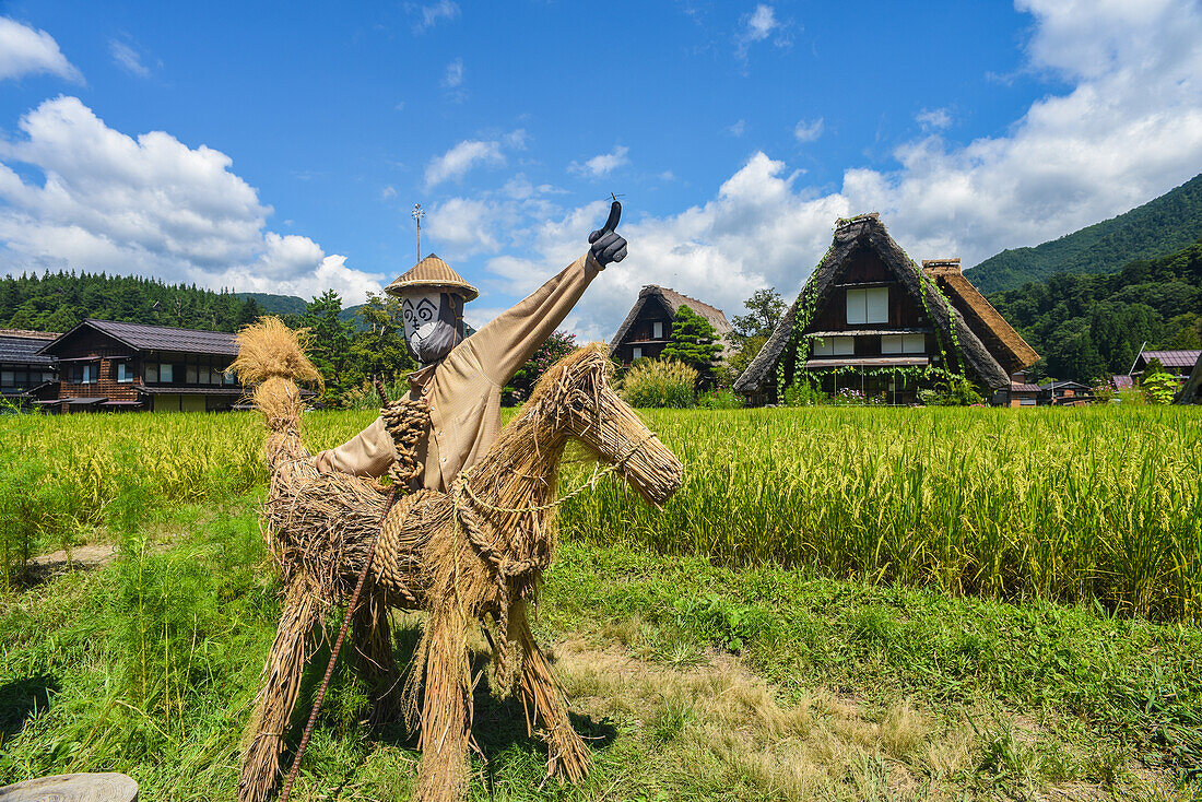 Scarecrows in front of traditional Gassho-Zukuri thatched wooden farmhouses in Shirakawa-go village, Gifu Prefecture, Japan