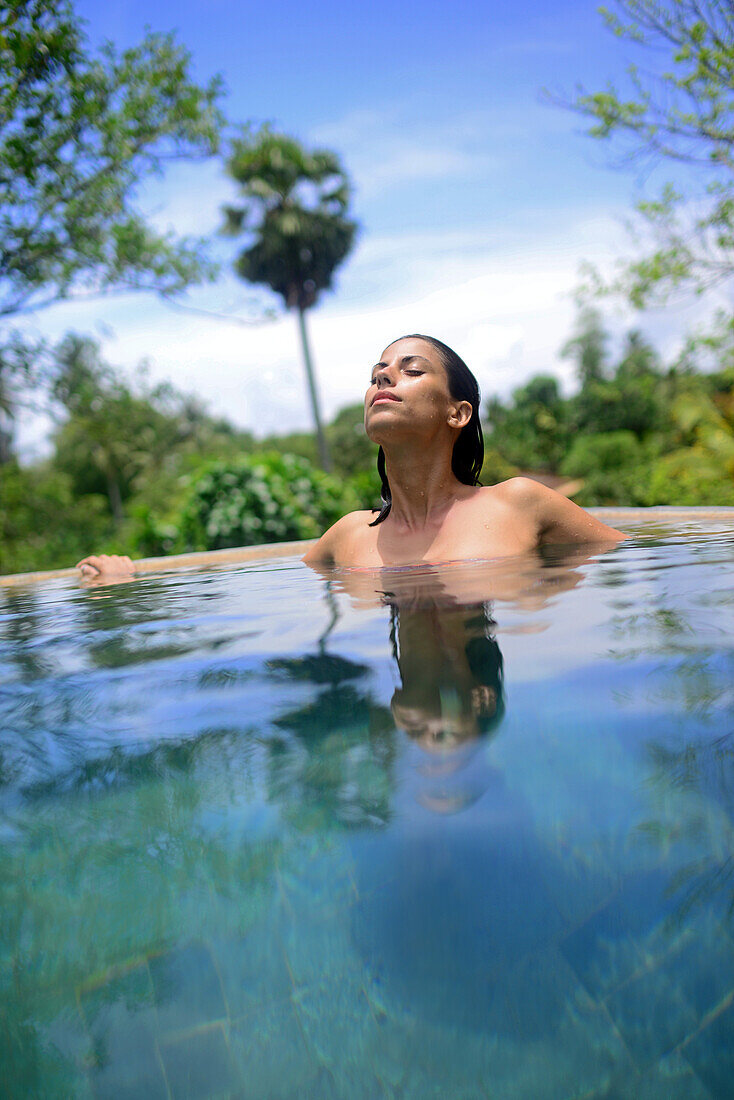 Junge attraktive Frau genießt ein Bad im Infinity-Swimmingpool des The Dutch House, Galle, Sri Lanka