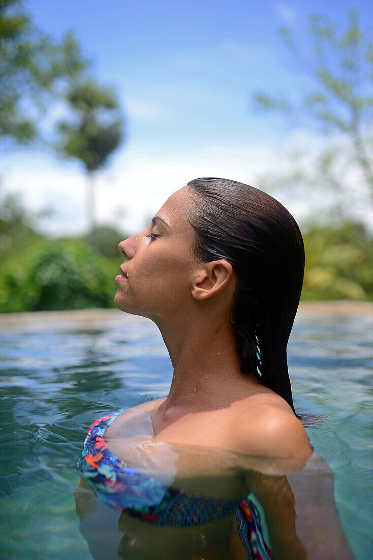 Young attractive woman enjoying a bath in the infinity edge swimming pool at The Dutch House, Galle, Sri Lanka