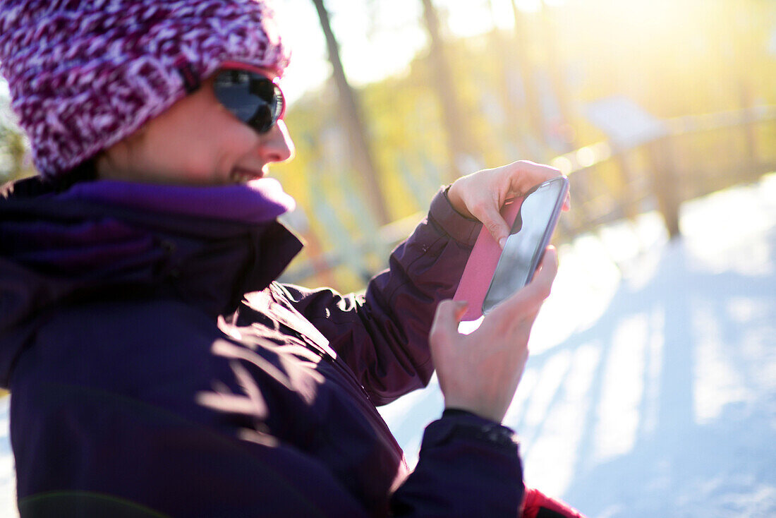 Young attractive woman using mobile telephone in Pyha ski resort, Lapland