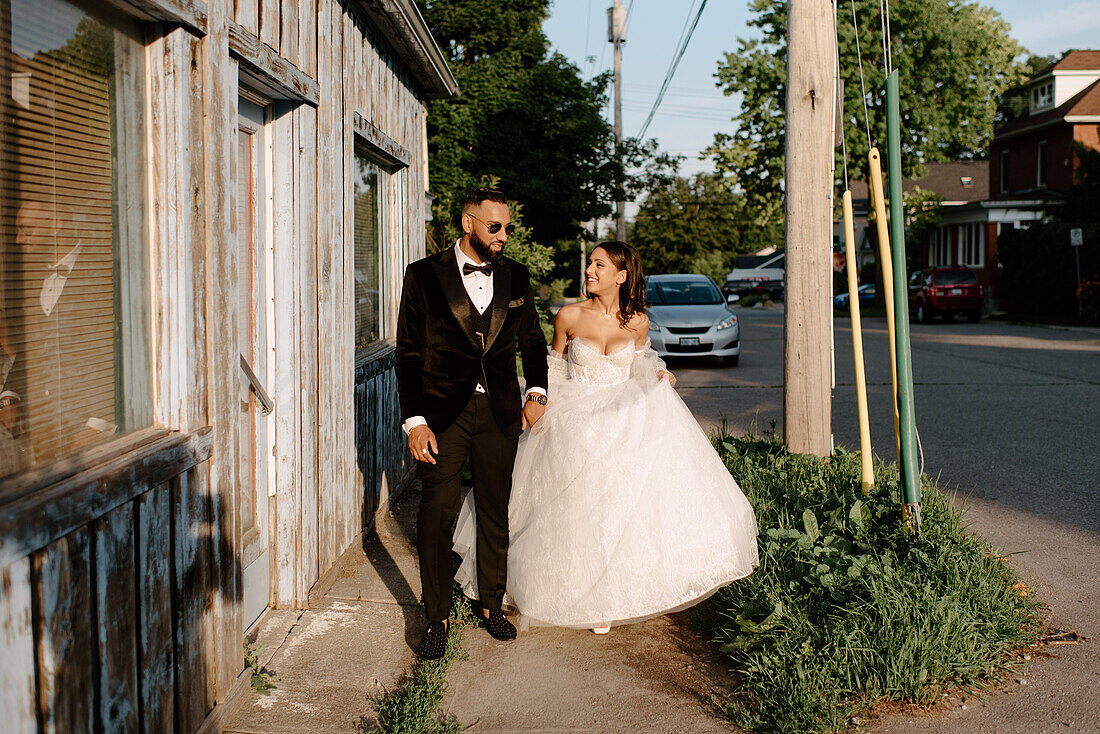 Braut und Bräutigam gehen auf dem Bürgersteig in der Stadt