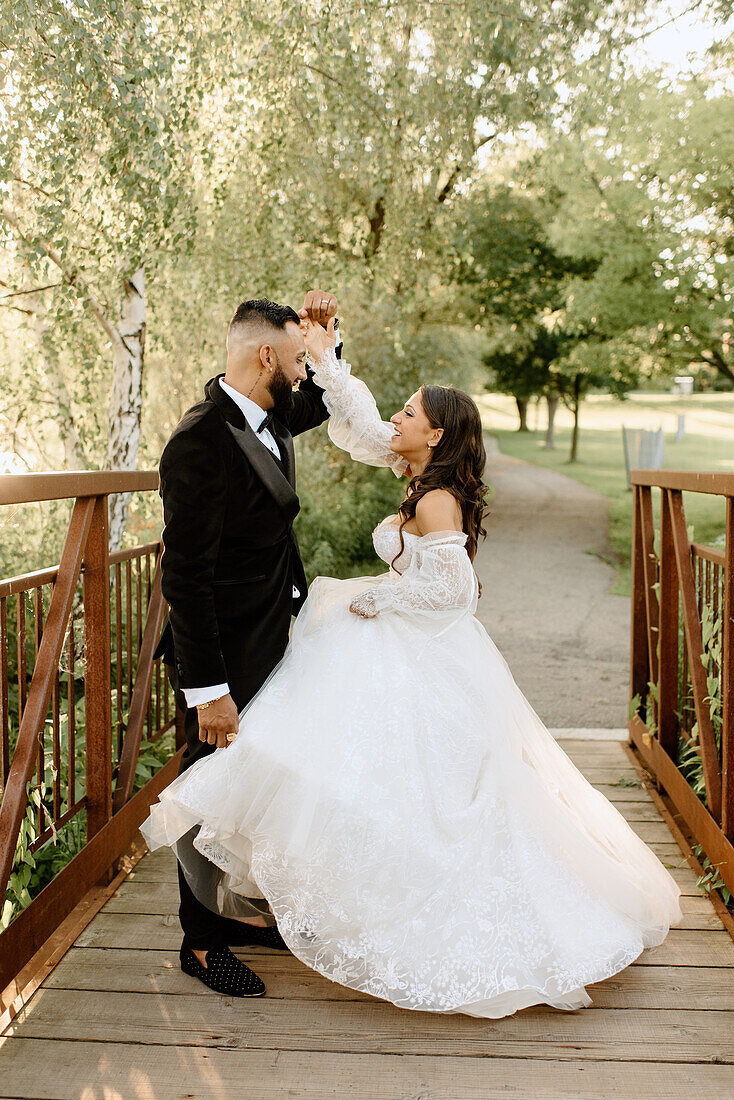 Braut und Bräutigam auf einem Steg im Park