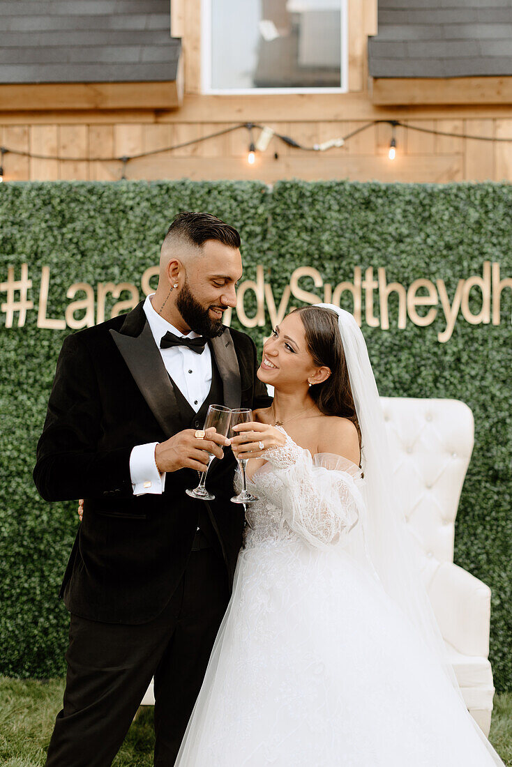 Smiling bride and groom holding champagne glasses