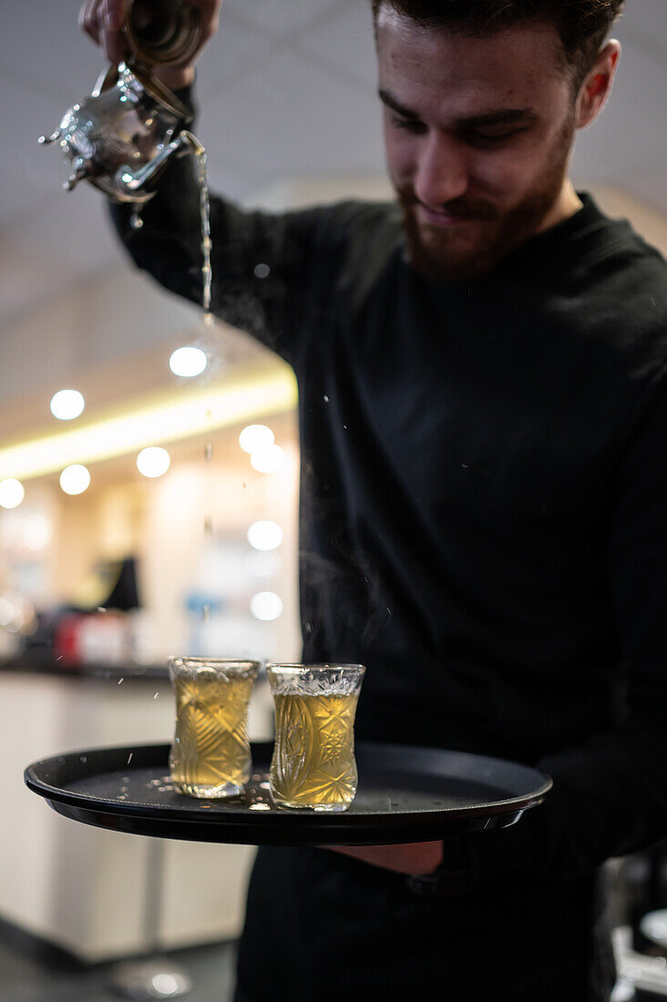 Waiter serving tea in Mosaico restaurant, Zaragoza, Spain