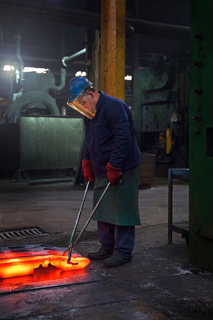 Fully forged and clipped flight bar (mining component) is lined up to cool down for final stage of finishing process