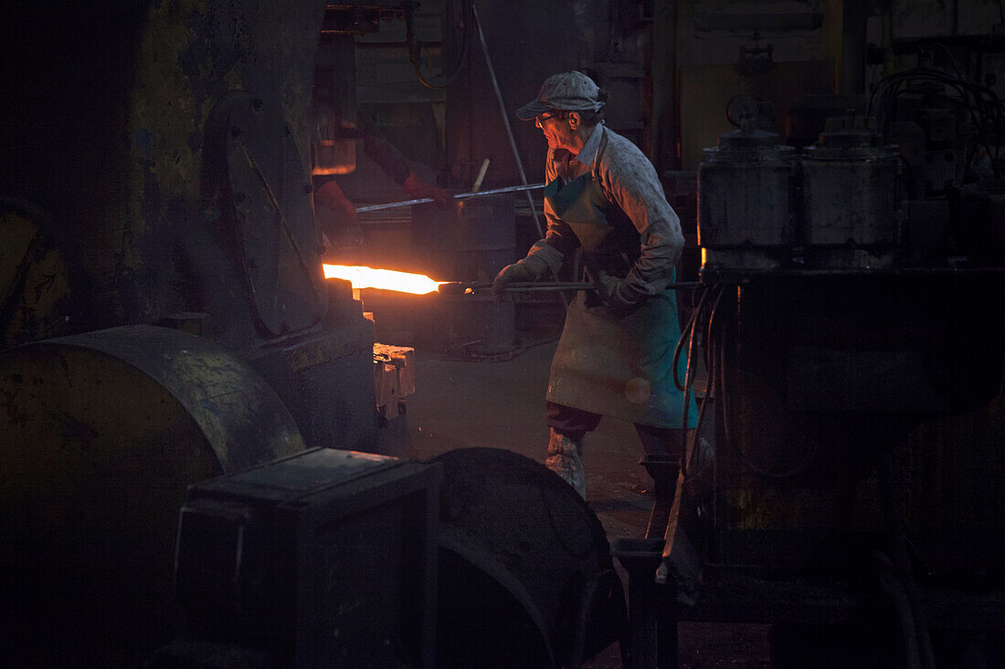 Inserting red hot steel billet into upset forge