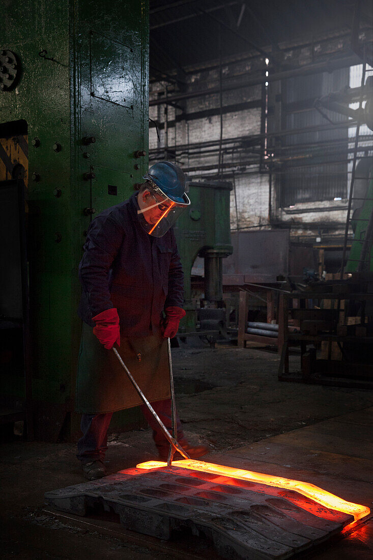 Fully forged and clipped flight bar (mining component) is lined up to cool down for final stage of finishing process