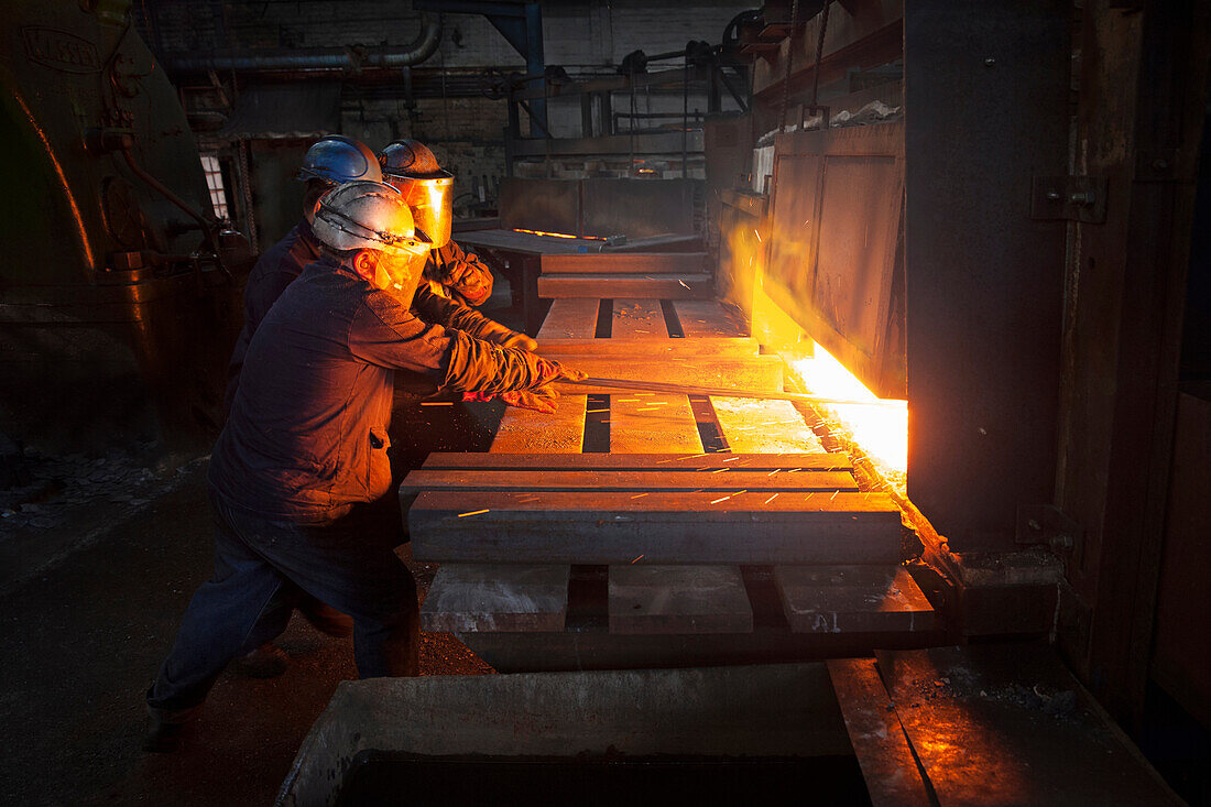 100mm square steel billet is removed from furnace as cold steel billet waits in foreground to be heated