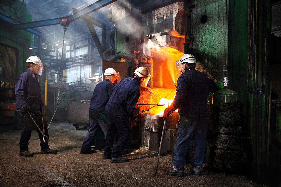 Flight bar (mining component) is manoeuvred with industrial tongs under the counterblow hammer