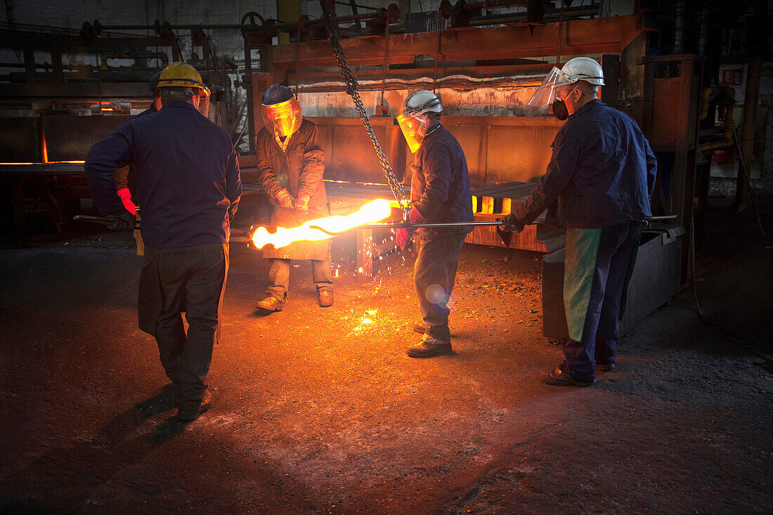 Red hot steel billet which has already been partially pre formed is moved back in to the furnace