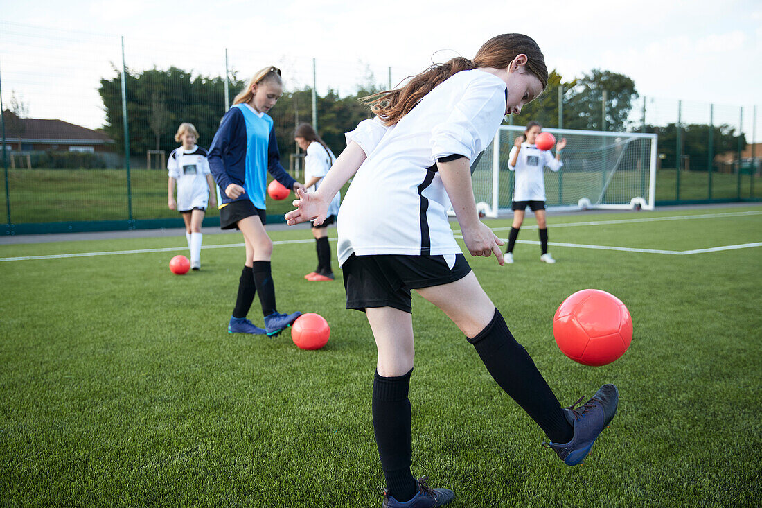UK, Mädchenfußballmannschaft (10-11, 12-13) beim Training auf einem Feld