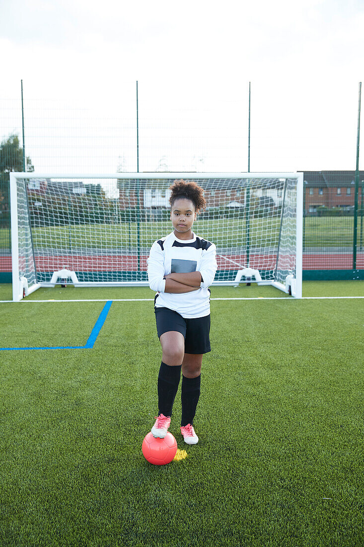 UK, Porträt einer Fußballspielerin (12-13) vor einem Tor