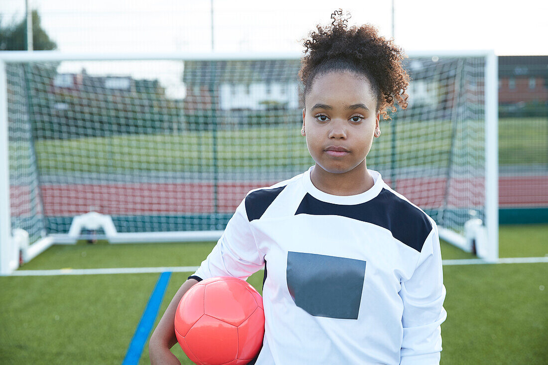 UK, Porträt einer Fußballspielerin (12-13) vor einem Tor