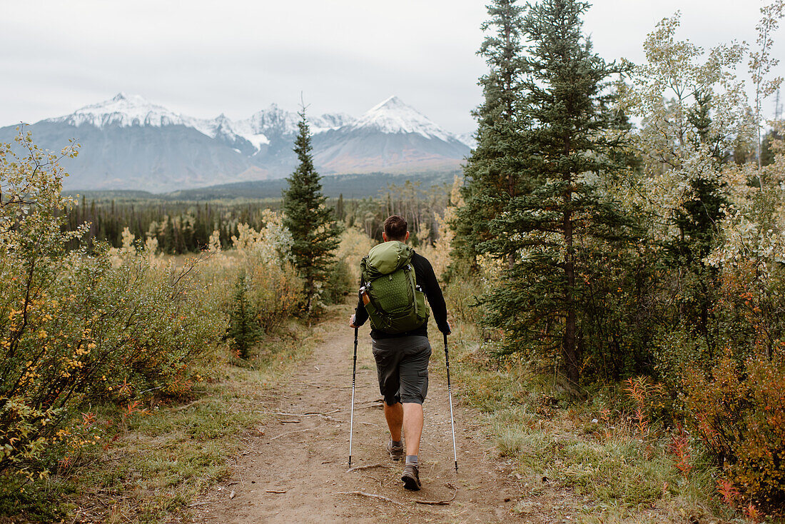 Kanada, Yukon, Whitehorse, Rückansicht eines Mannes beim Wandern in einer Berglandschaft