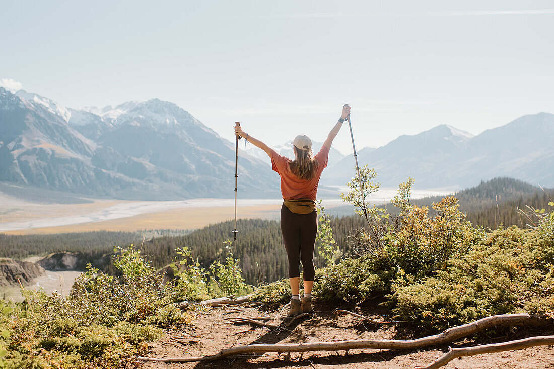 Kanada, Whitehorse, Rückansicht einer Frau mit Wanderstöcken in einer Landschaft