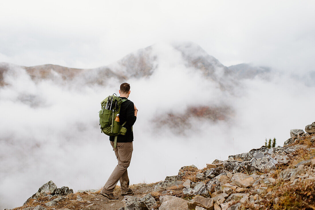 Kanada, Whitehorse, Mann mit Rucksack beim Wandern in felsiger Landschaft