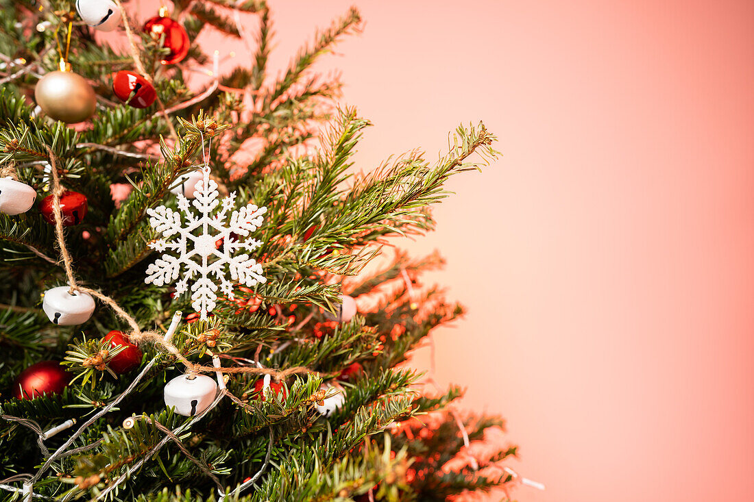 Weihnachtsbaum mit Ornamenten auf rosa Hintergrund