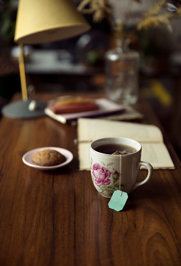Tea, cookie and book on desk