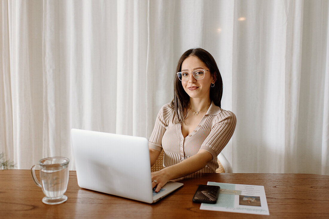 Portrait of young businesswoman working on laptop