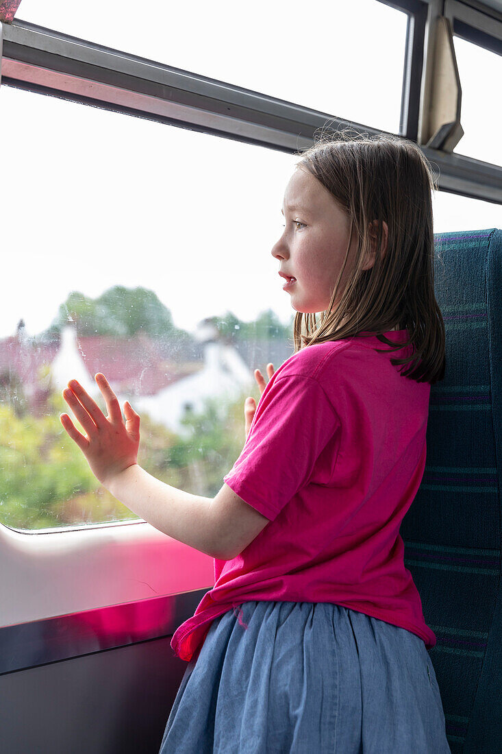 Girl (4-5)Êlooking through window in train
