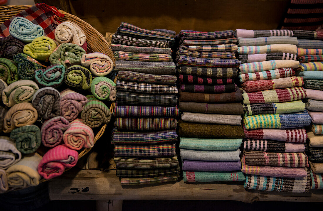 Kambodscha, Siem Reap, Stapel von gefalteten und aufgerollten Textilien zum Verkauf
