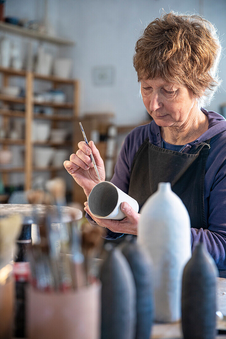 Spain, Baleares, Woman painting ceramics in workshop