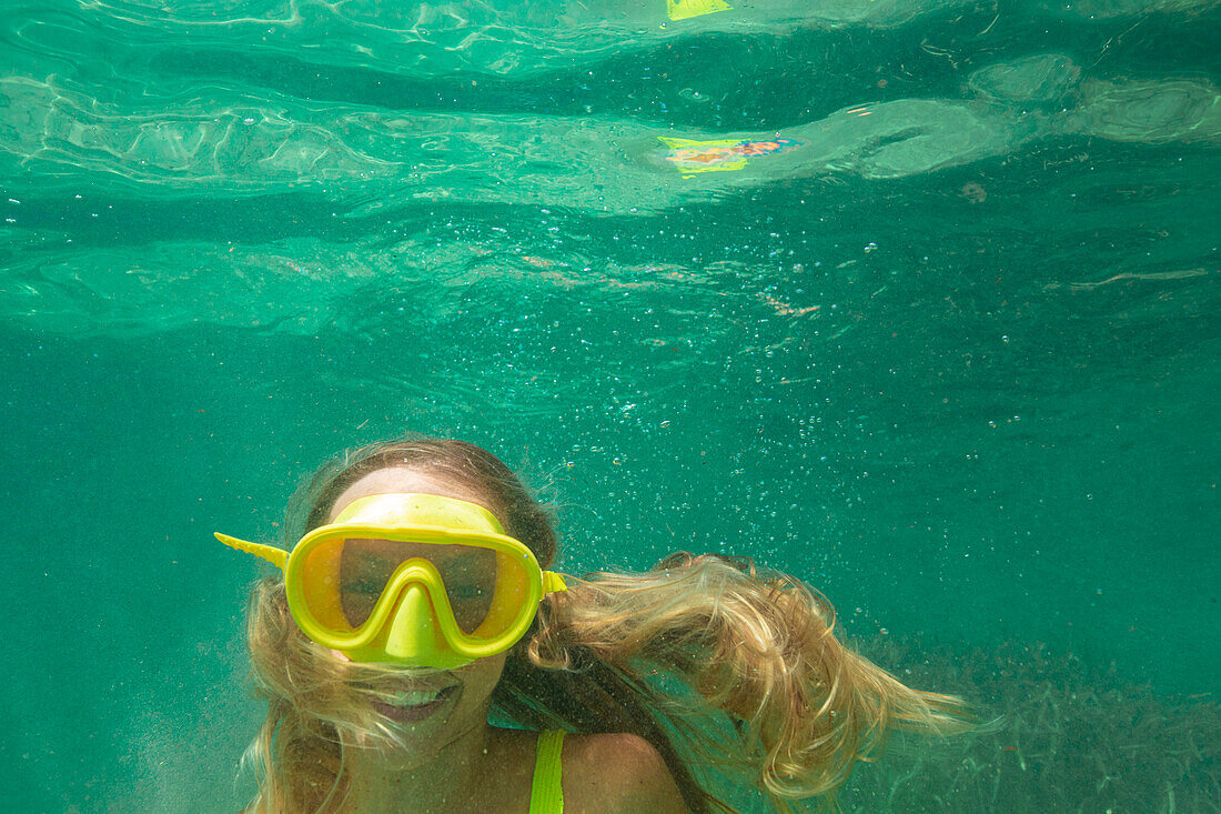 Spain, Mallorca, Smiling woman in scuba mask diving in sea