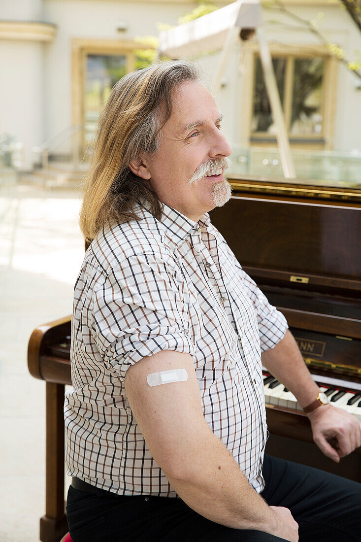 Österreich, Porträt eines Pianisten mit Klebeband am Arm