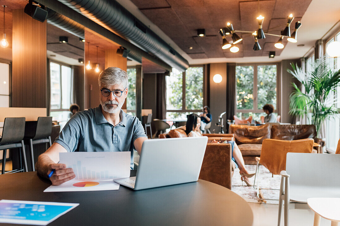 Italy, Businessman working at table in creative studio