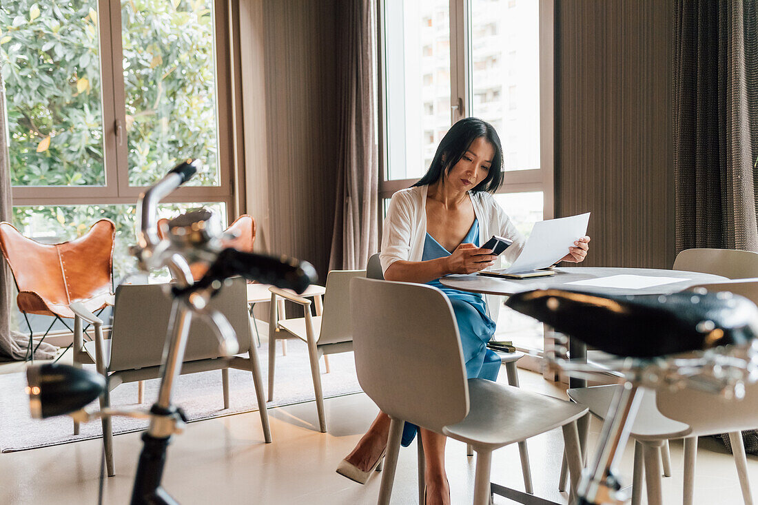 Italy, Businesswoman working at table in creative studio