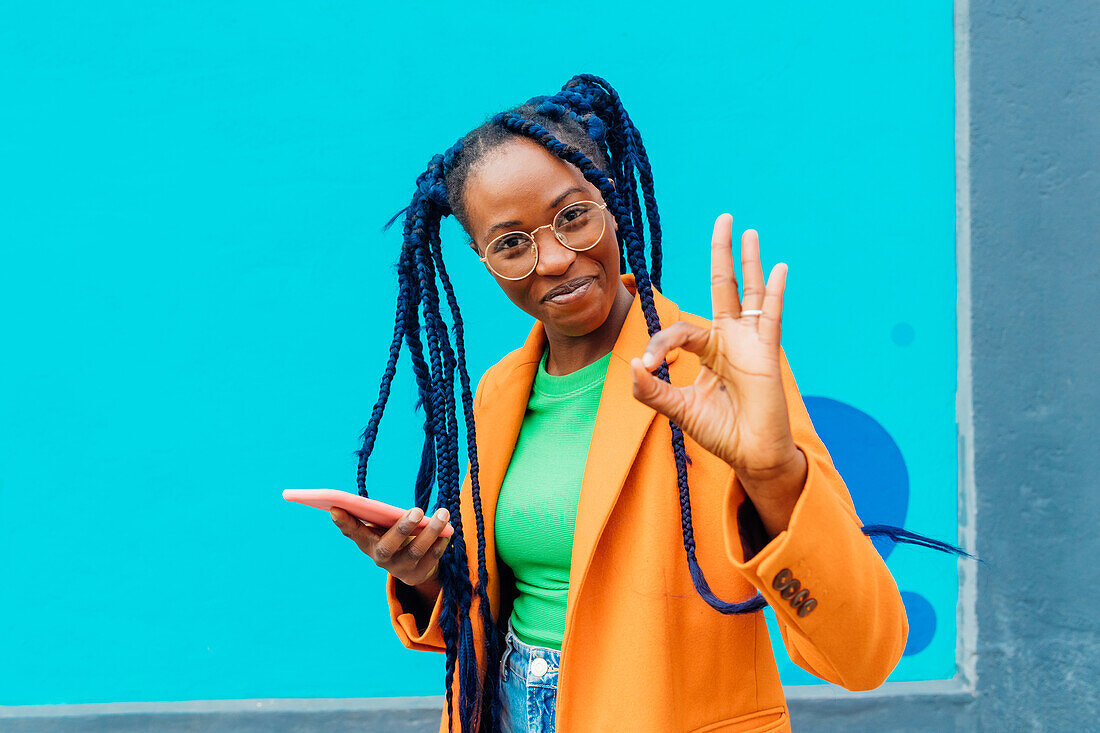 Italy, Milan, Woman with braids making Okay sign