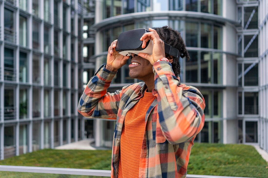Deutschland, Berlin, Mann benutzt Virtual-Reality-Brille in der Stadt