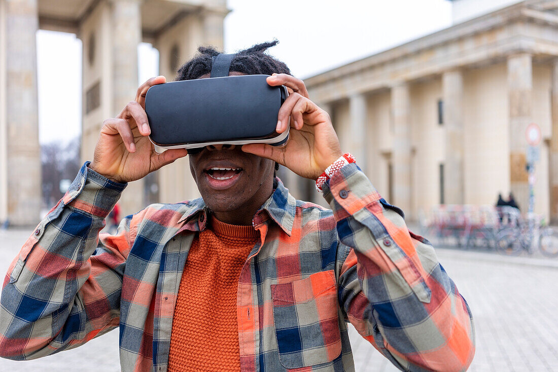 Germany, Berlin, Man using virtual reality goggles in city